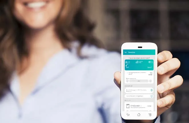 Kobieta pokazuje smartfon z aplikacją Renhold do zamawiania sprzątania